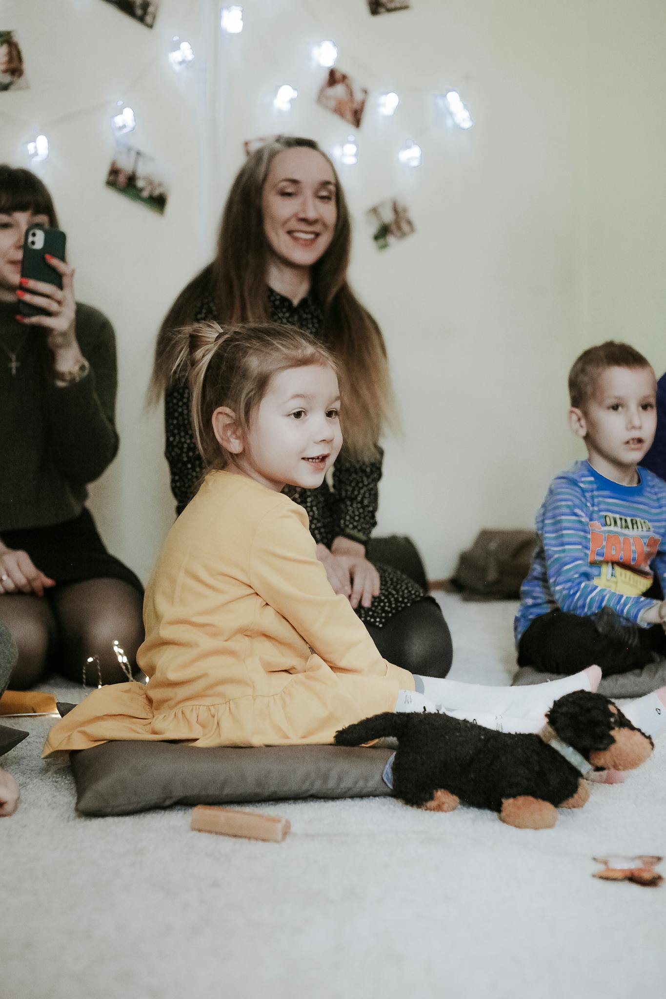 A cozy indoor scene of children and adults bonding and playing together.